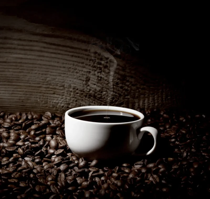Dampende kop koffie op koffiebonen